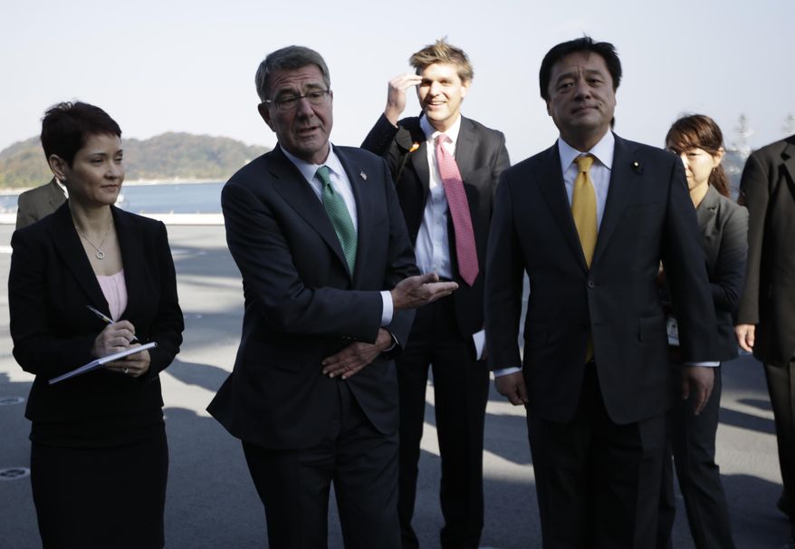United States Secretary of Defense Ash Carter, second left, speaks to the media as Japanese Deputy Defense Minister Kenji Wakamiya, right, accompanies on the flight deck of the helicopter destroyer Izumo of Japan's Maritime Self-Defense Force (JMSDF) in Yokosuka, south of Tokyo, Tuesday, Dec. 6, 2016. Carter's final swing across Asia as Pentagon chief shines a spotlight on tough issues to be inherited by his successor, from concern in Tokyo and Seoul about being forced to pay more for U.S. military protection to worry across the region about North Korea's nuclear ambitions. (AP Photo/Eugene Hoshiko)