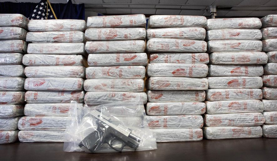 FILE - This Tuesday, May 19, 2015 file photo shows a firearm and 154 pounds of heroin worth at least $50 million displayed during a Drug Enforcement Administration news conference in New York. According to government data released Thursday, Dec. 8, 2016, drug overdose deaths in the U.S. surpassed 50,000 in 2015, the highest mark in at least 15 years. (AP Photo/Mark Lennihan)