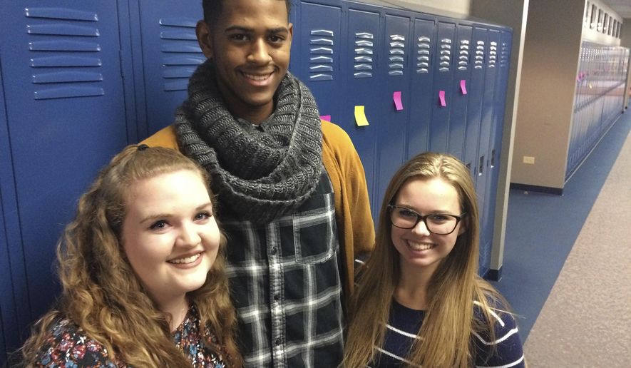 ADVANCE FOR USE SUNDAY, DEC. 11, 2016 AND THEREAFTER - In this Nov. 15, 2016 photo, students at Warren Township High School's junior-senior Almond Road campus in Gurnee, Ill., from left, Kathryn Haynes, Jaylen Davis and Amanda Middleton were among those who wrote positive messages on sticky notes and posted them on all 2,500 lockers in response to racist graffiti that was found on bathroom stalls at Warren's two campuses the previous week. (Bob Susnjara/Daily Herald, via AP)