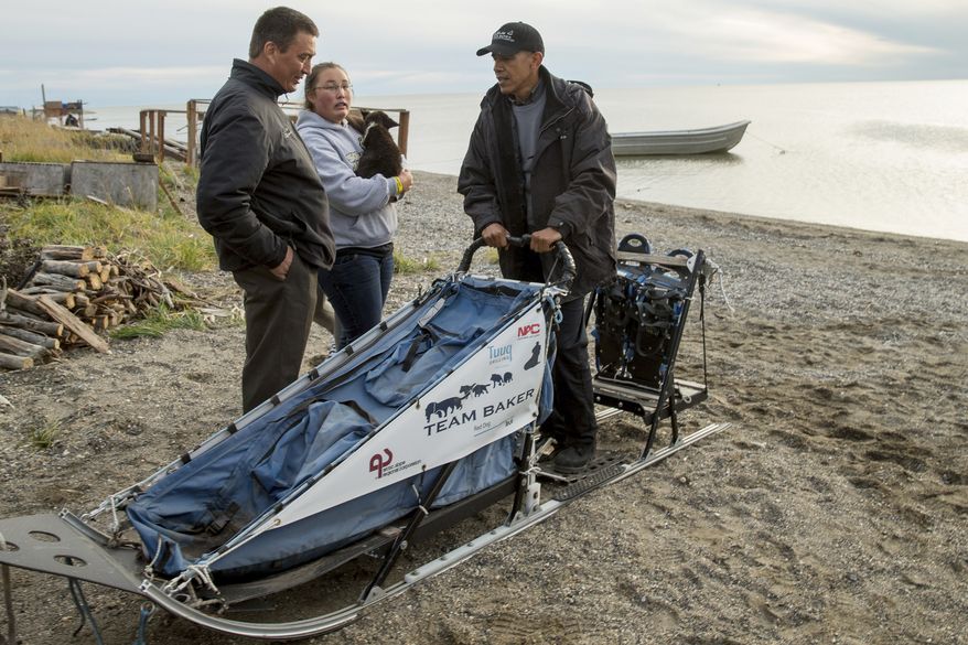 In this Sept. 2, 2015, file photo President Barack Obama meets with Kevin Baker, left, the 2011 Iditarod winner on Kotzebue Shore Avenue, which has dealt with erosion problems, in Kotzebue, Alaska. Obama used his executive powers Friday, Dec. 9, to add protections to waters off Alaska's west coast. (AP Photo/Andrew Harnik, File)