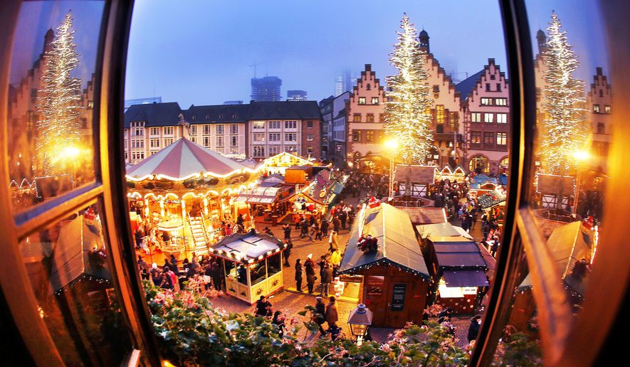 FILE - In this Dec. 8, 2016 photo people enjoy a stroll at the traditional Christmas market in Frankfurt, Germany. (AP Photo/Michael Probst, file)