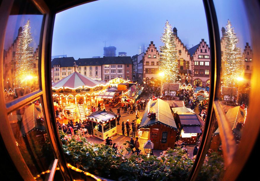 FILE - In this Dec. 8, 2016 photo people enjoy a stroll at the traditional Christmas market in Frankfurt, Germany. (AP Photo/Michael Probst, file)