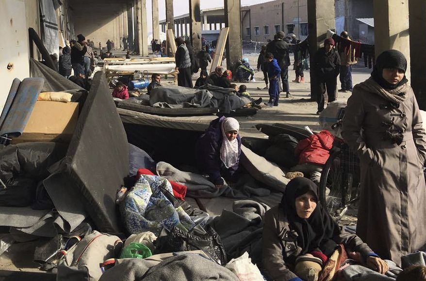 This image released by the International Committee for the Red Cross (ICRC) shows Syrians who were displaced with their families from eastern Aleppo gather at the collective shelter, in the village of Jibreen south of Aleppo, Syria, Monday, Dec. 12, 2016. Syria's military said Monday it has regained control of 98 percent of eastern Aleppo, as government forces close in the last remaining sliver of a rebel enclave packed with fighters as well as tens of thousands of civilians. (ICRC via AP)