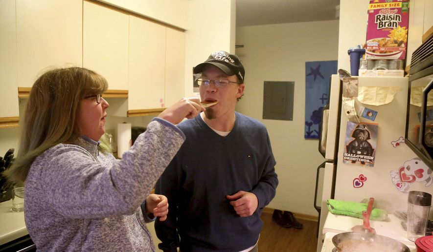 In a Wednesday, Dec. 7, 2016 photo, Steve Allen gets a taste of the sauce from his girlfriend Candace Hanson-Johnson in the apartment Hanson-Johnson shares with her mom, in Eagan, Minn. Allen, 34, who has a cognitive disability, has dreams of one day marrying his sweetheart Hanson-Johnson, 26. The two have been dating for six years. But Steve's main obstacle is his guardian, who continues to exert broad control over his life. A coalition of Minnesota nonprofits is developing an alternative to a system in which vulnerable adults in the state live under the supervision of a court-appointed guardian who has broad authority over the money, medical care and personal relationships of their wards. (David Joles/Star Tribune via AP)