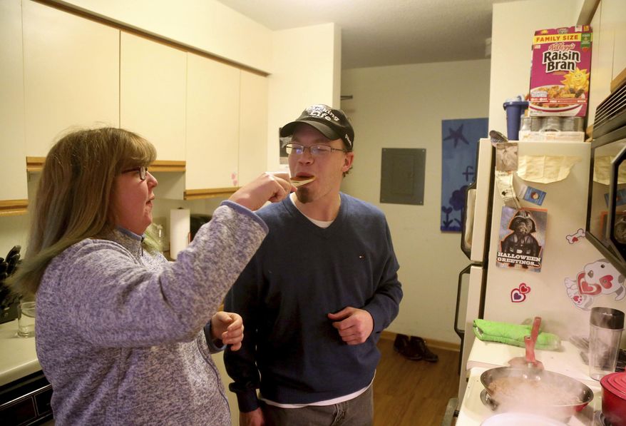 In a Wednesday, Dec. 7, 2016 photo, Steve Allen gets a taste of the sauce from his girlfriend Candace Hanson-Johnson in the apartment Hanson-Johnson shares with her mom, in Eagan, Minn. Allen, 34, who has a cognitive disability, has dreams of one day marrying his sweetheart Hanson-Johnson, 26. The two have been dating for six years. But Steve's main obstacle is his guardian, who continues to exert broad control over his life. A coalition of Minnesota nonprofits is developing an alternative to a system in which vulnerable adults in the state live under the supervision of a court-appointed guardian who has broad authority over the money, medical care and personal relationships of their wards. (David Joles/Star Tribune via AP)