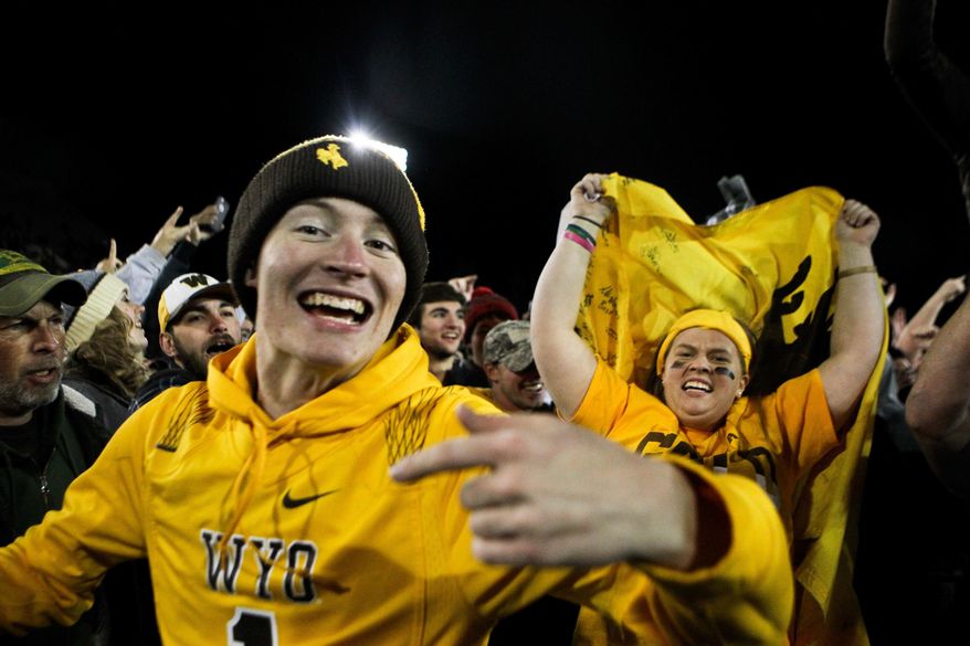 FILE - In this Saturday, Nov. 19, 2016, file photo, Wyoming fans react after the team defeated San Diego State 34-33 in Laramie, Wyo. By all accounts, Wyoming's football program has made a remarkable turnaround from a team that last had a winning season in 2011 and won just two games last year. But Cowboys coach Craig Bohl isn't satisfied with one good year: he wants a program that is a consistent winner over multiple seasons. (AP Photo/Shannon Broderick, File)