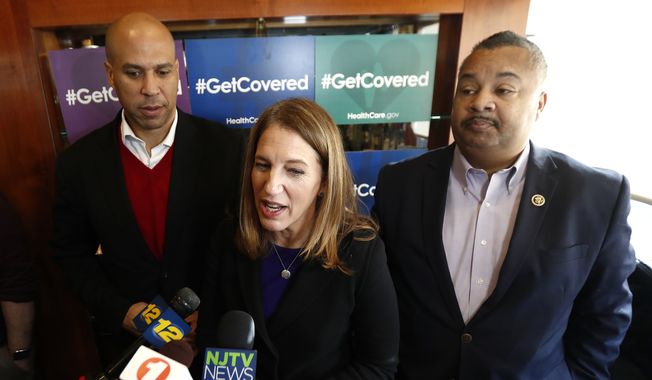 U.S. Department of Health and Human Services Secretary Sylvia Burwell, center, stands with U.S. Sen. Cory Booker, D-N.J., left, and U.S. Rep. Donald Payne, Jr., D-N.J., while talking to reporters during a visit to Tops Diner to talk about the Affordable Care Act, Wednesday, Dec. 14, 2016, in East Newark, N.J. Rep. Payne Jr. died Wednesday after suffering a heart attack earlier in the month. (AP Photo/Julio Cortez)