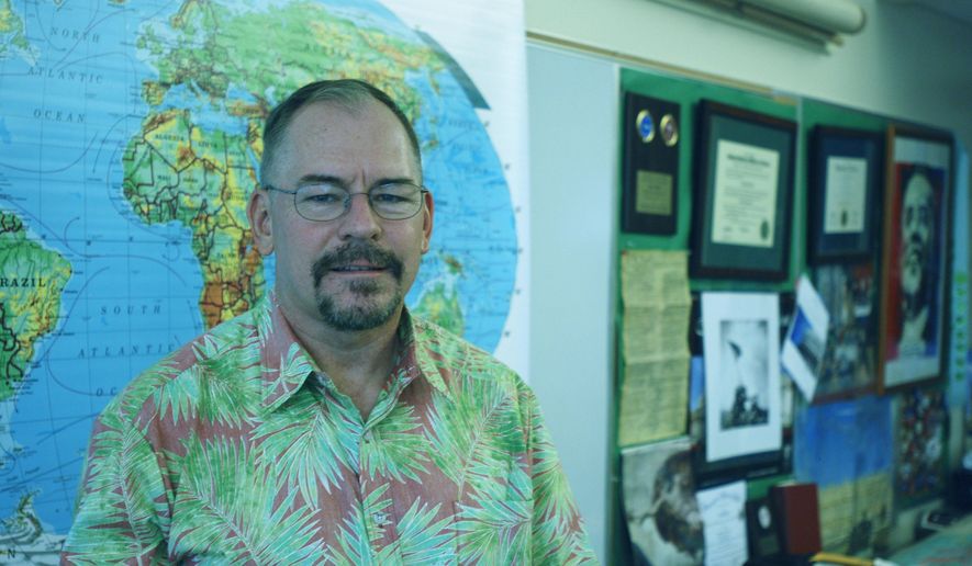 Electoral College elector John Bickel, a Hawaii Democrat, poses in his classroom at Iolani High School on Wednesday, Dec. 14, 2016 in Honolulu. Bickel, who says he plans to vote for Hillary Clinton, recently joined a movement to request information about possible Russian hacking during the presidential election. (AP Photo/Cathy Bussewitz)