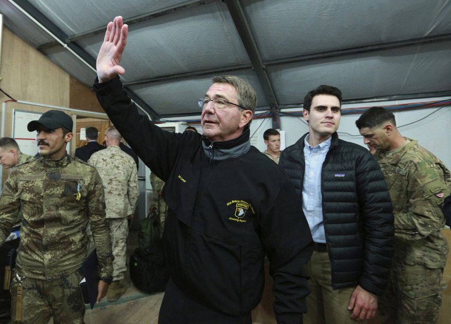 In this Dec. 11, 2016, photo, U.S. Defense Secretary Ash Carter waves to a group of Iraqi and U.S. soldiers during his visit to the Qayara air base, south of Mosul, Iraq. Carter is convening his final war-planning conference with core members of the anti-Islamic State coalition. The session gets underway Dec. 15 in London amid questions within the coalition about what President-elect Donald Trump’s arrival in the White House next month will mean for the future of the coalition. (AP Photo/Hadi Mizban)