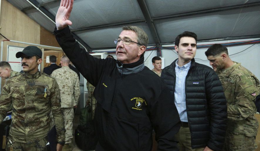 In this Dec. 11, 2016, photo, U.S. Defense Secretary Ash Carter waves to a group of Iraqi and U.S. soldiers during his visit to the Qayara air base, south of Mosul, Iraq. Carter is convening his final war-planning conference with core members of the anti-Islamic State coalition. The session gets underway Dec. 15 in London amid questions within the coalition about what President-elect Donald Trump’s arrival in the White House next month will mean for the future of the coalition. (AP Photo/Hadi Mizban)