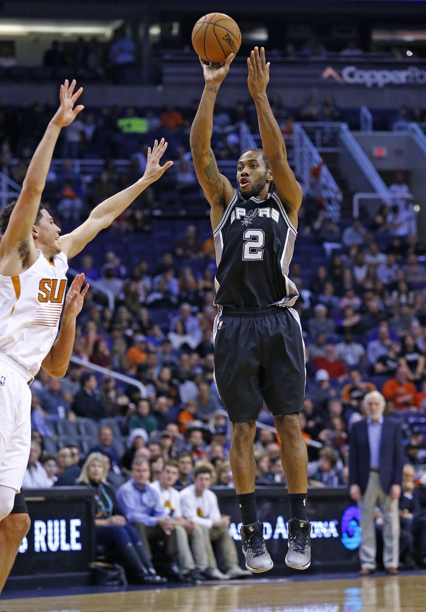 San Antonio Spurs forward Kawhi Leonard (2) shoots over Phoenix Suns guard Devin Booker, left, during the first half of an NBA basketball game Thursday, Dec. 15, 2016, in Phoenix. (AP Photo/Ross D. Franklin)