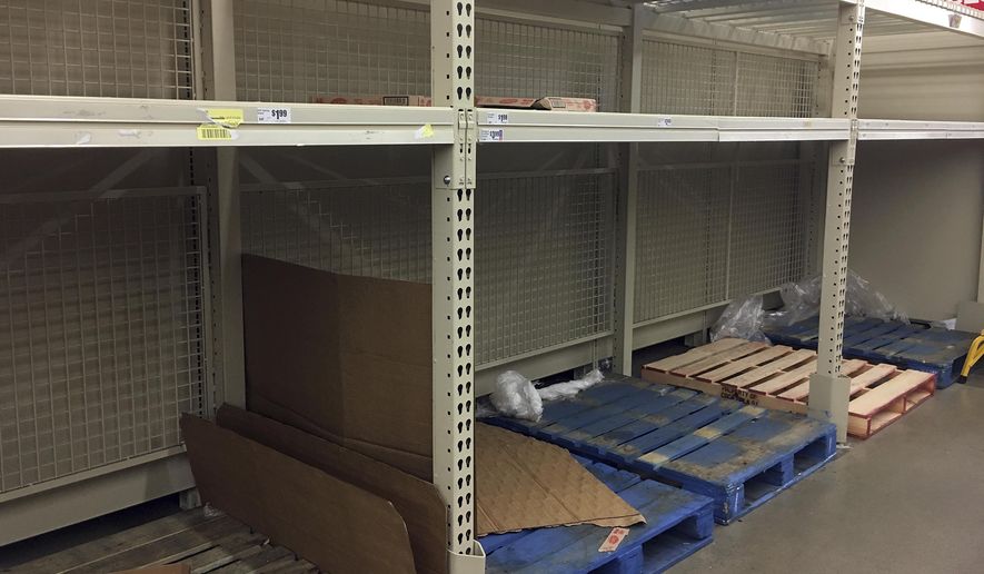 In this Thursday, Dec. 15, 2016 photo, empty shelves are left after residents rushed to H-E-B to buy water after a recent back-flow incident in the industrial district according to a city news release, in Corpus Christi, Texas. (Gabe Hernandez/Corpus Christi Caller-Times via AP)