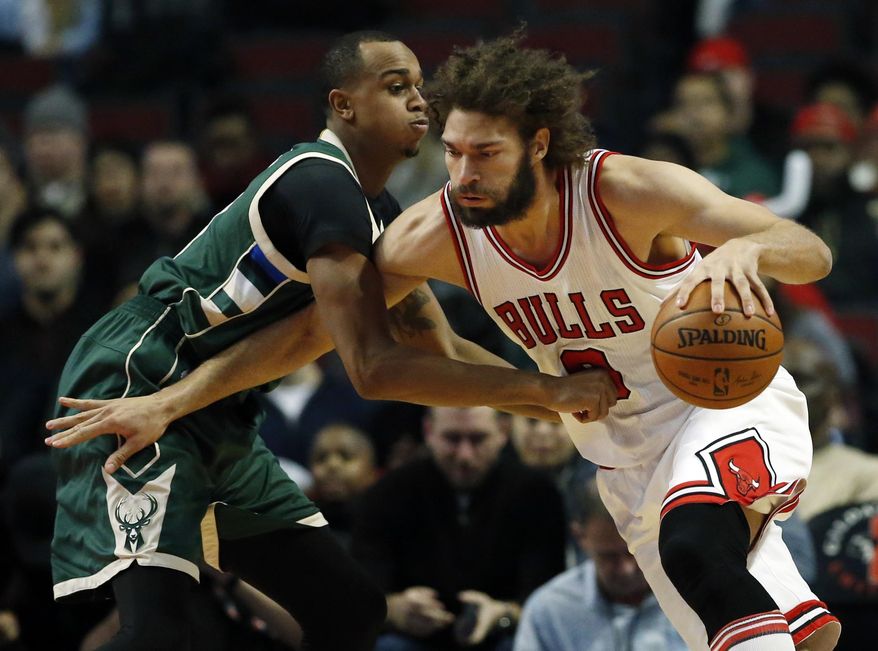 Chicago Bulls center Robin Lopez, right, drives against Milwaukee Bucks forward John Henson during the first half of an NBA basketball game Friday, Dec. 16, 2016, in Chicago. (AP Photo/Nam Y. Huh)