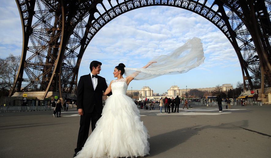 Rodrigo and Nancy of Mexico pose for a photographer under the Eiffel Tower as they are on honeymoon in Paris, Friday, Dec. 16, 2016. (AP Photo/Christophe Ena)