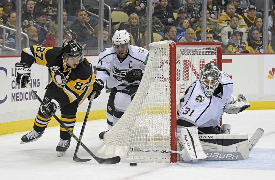 Pittsburgh Penguins center Sidney Crosby (87) passes the puck past Los Angeles Kings center Anze Kopitar (11) and Los Angeles Kings goalie Peter Budaj (31) during the second period of an NHL hockey game on Friday, Dec. 16, 2016, in Pittsburgh. (AP Photo/Fred Vuich)