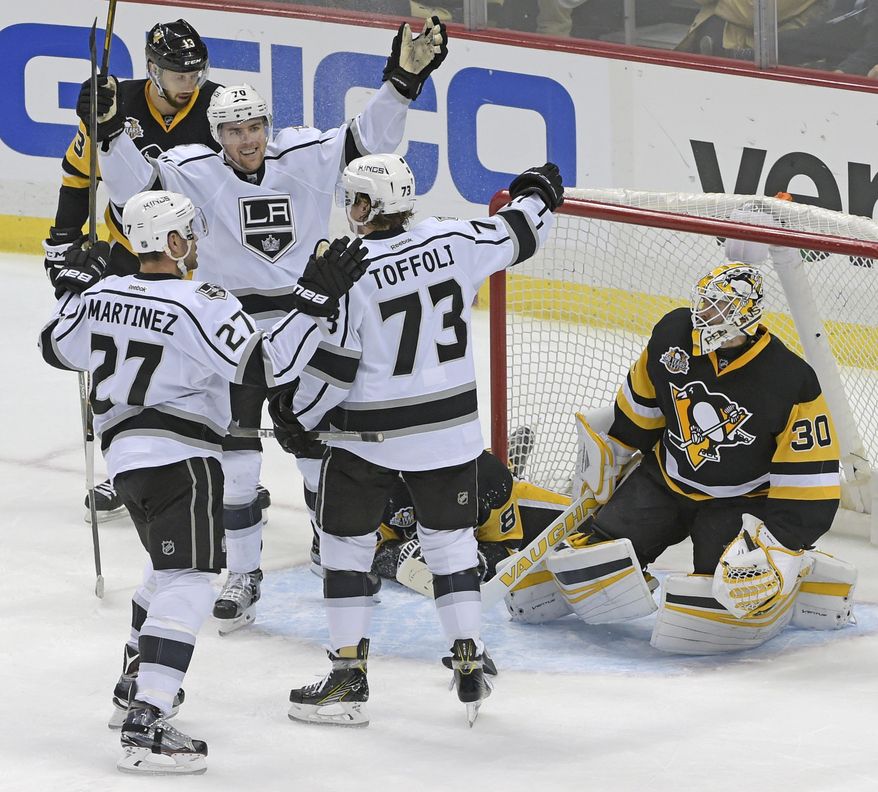 Los Angeles Kings defenseman Alec Martinez (27), left wing Tanner Pearson (70), and center Tyler Toffoli (73) celebrate the winning goal next to Pittsburgh Penguins goalie Matt Murray (30) during the overtime period of an NHL hockey game on Friday, Dec. 16, 2016, in Pittsburgh. (AP Photo/Fred Vuich)