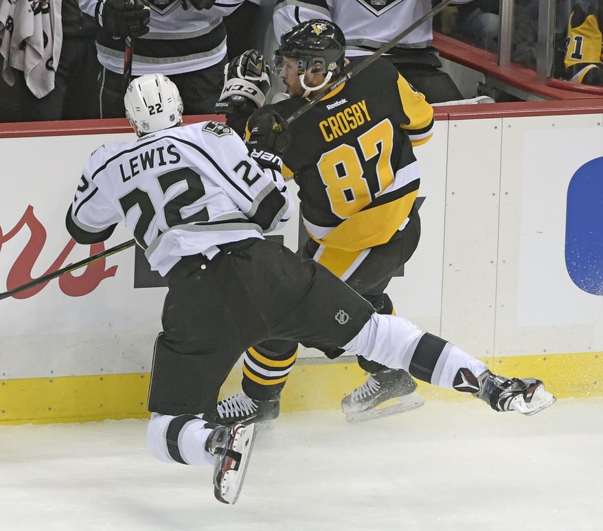 Pittsburgh Penguins center Sidney Crosby (87) checks Los Angeles Kings center Trevor Lewis (22) during the first period of an NHL hockey game on Friday, Dec. 16, 2016, in Pittsburgh. (AP Photo/Fred Vuich)