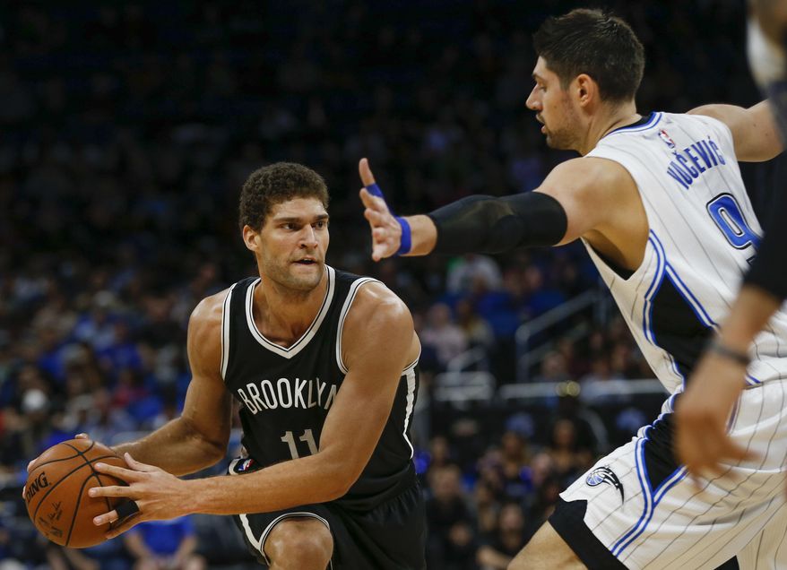 Brooklyn Nets center Brook Lopez (11) looks to pass around Orlando Magic center Nikola Vucevic (9) during the second quarter of an NBA basketball game in Orlando, Fla., on Friday, Dec. 16, 2016. (AP Photo/Reinhold Matay)