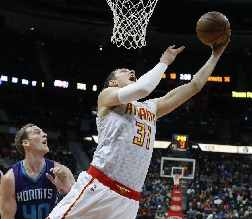 Atlanta Hawks forward Mike Muscala (31) scores as Charlotte Hornets center Cody Zeller (40) defends in the first half of an NBA basketball game Saturday, Dec. 17, 2016, in Atlanta. (AP Photo/John Bazemore)