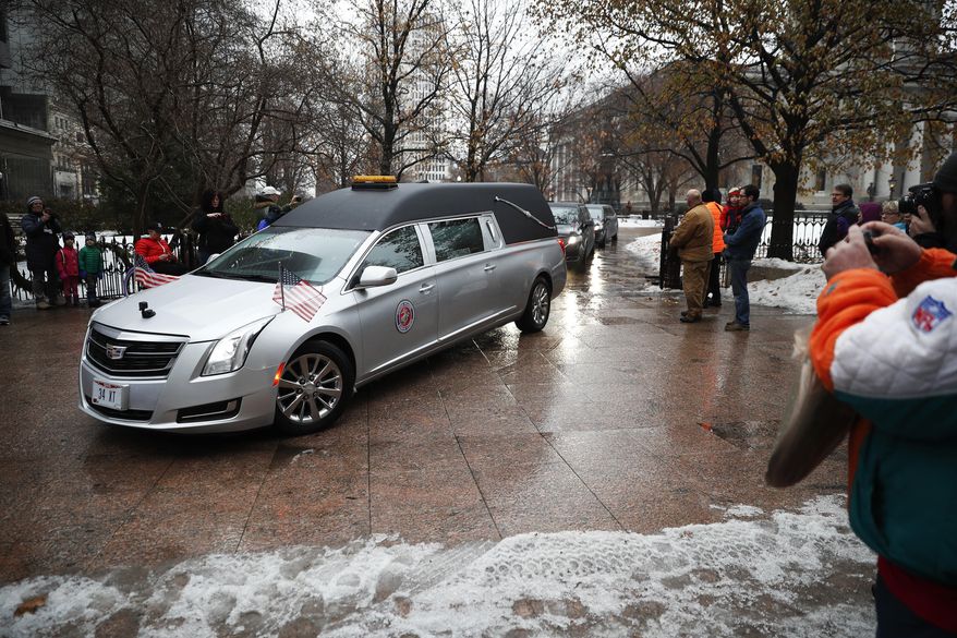 A hearse bearing the casket of John Glenn is driven away from the Ohio Statehouse during his funeral procession, Saturday, Dec. 17, 2016, in Columbus, Ohio. The famed astronaut died Dec. 8 at age 95. (AP Photo/John Minchillo)