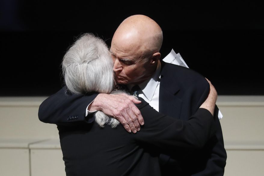 David Glenn, right, hugs his sister, Carolyn Ann, after they spoke at their father John Glenn's funeral at The Ohio State University, Saturday, Dec. 17, 2016, in Columbus, Ohio. Glenn, the famed astronaut, died Dec. 8 at age 95. (AP Photo/John Minchillo)