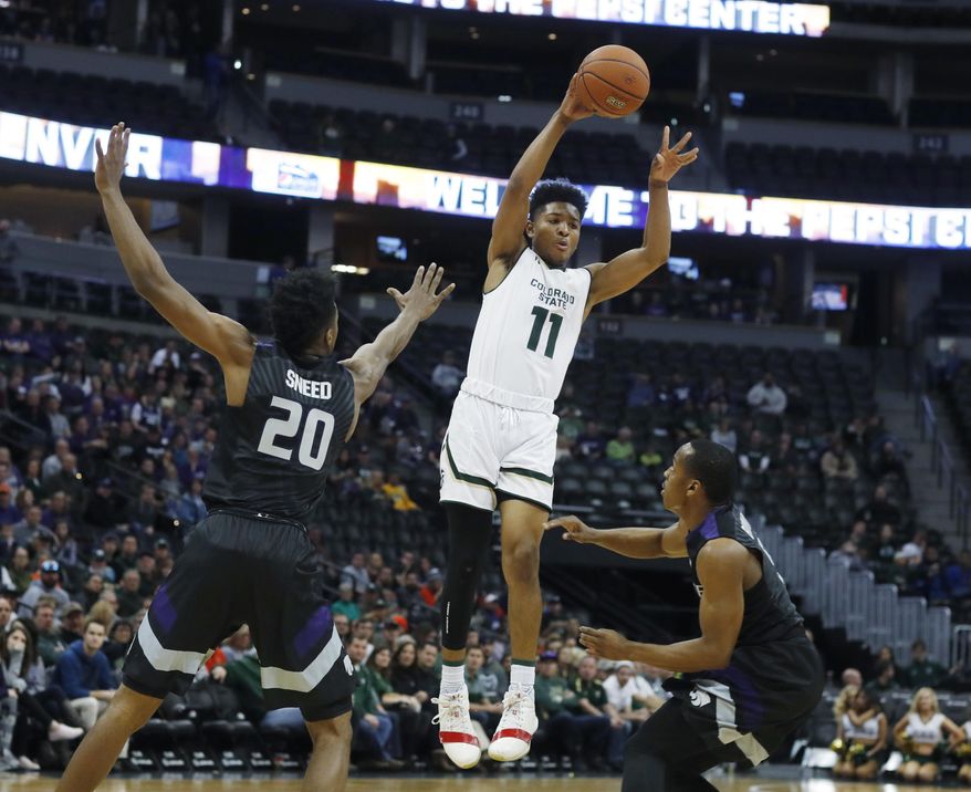 Colorado State guard Prentiss Nixon, center, jumps and passes the ball over Kansas State forward Xavier Sneed, left, and guard Barry Brown during the first half of an NCAA college basketball game Saturday, Dec. 17, 2016, in Denver. (AP Photo/David Zalubowski)
