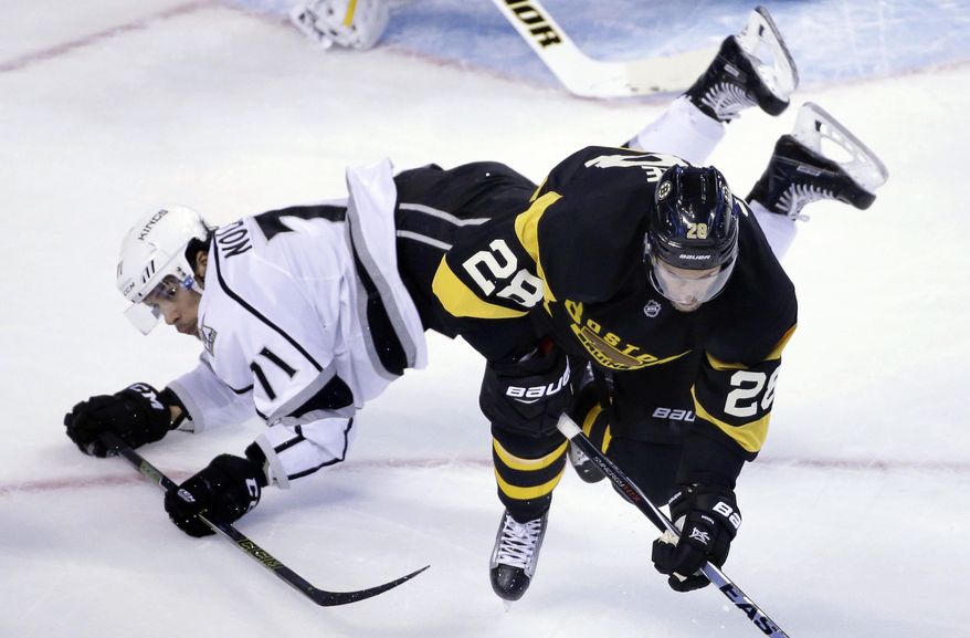Los Angeles Kings center Jordan Nolan, left, and Boston Bruins center Dominic Moore, right, hit the ice after colliding in the first period of an NHL hockey game, Sunday, Dec. 18, 2016, in Boston. (AP Photo/Steven Senne)