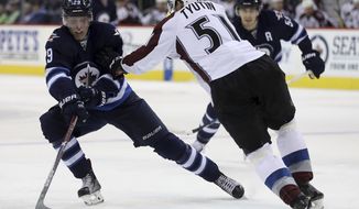 Winnipeg Jets&#39; Patrik Laine (29) uses some fancy moves on Colorado Avalanche&#39;s Fedor Tyutin (51)  during the second period of an NHL hockey game, Sunday, Dec. 18, 2016 in Winnipeg, Manitoba. (Trevor Hagan/The Canadian Press via AP)