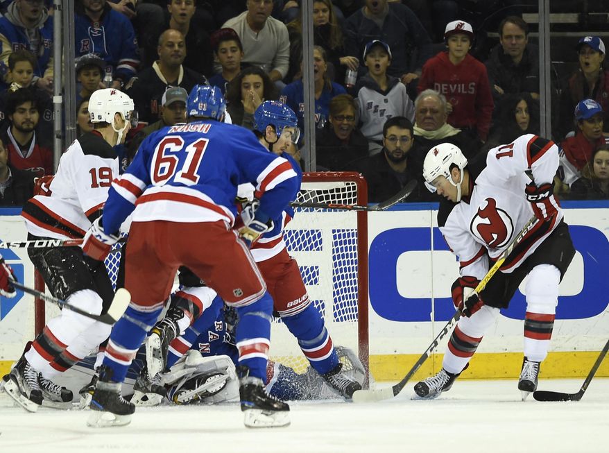New Jersey Devils right wing PA Parenteau (11) shoots the puck past New York Rangers right wing Rick Nash (61), defenseman Ryan McDonagh (27) and goalie Henrik Lundqvist (30) to score in the second period of an NHL hockey game in New York, Sunday, Dec. 18, 2016. (AP Photo/Kathy Kmonicek)