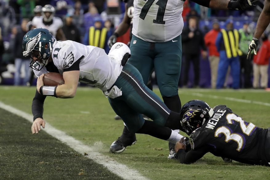 Philadelphia Eagles quarterback Carson Wentz (11) dives into the end zone on a quarterback keeper as Baltimore Ravens strong safety Eric Weddle (32) hangs on during the second half of an NFL football game in Baltimore, Sunday, Dec. 18, 2016. The Ravens defeated the Eagles 27-26. (AP Photo/Patrick Semansky)