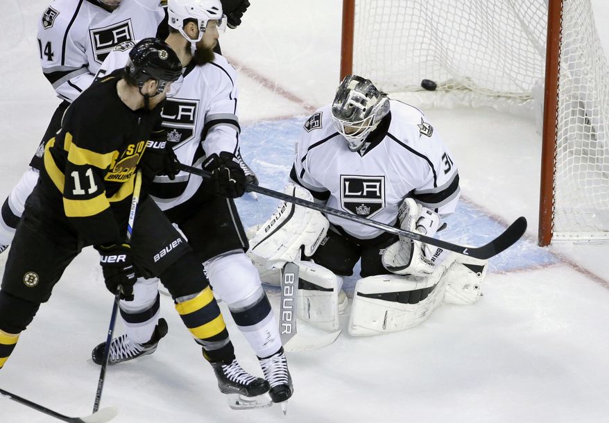 Boston Bruins right wing Jimmy Hayes (11) shoots the puck past Los Angeles Kings defenseman Jake Muzzin, center left, and goalie Peter Budaj (31), of Slovakia, and into the net to score in the first period of an NHL hockey game, Sunday, Dec. 18, 2016, in Boston. (AP Photo/Steven Senne)