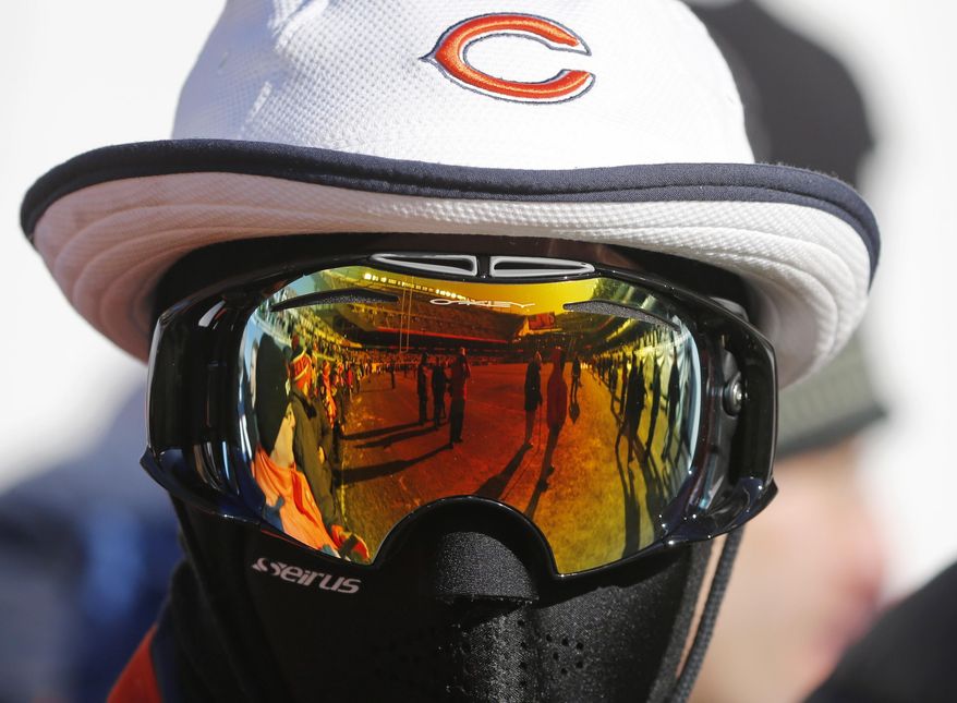 A Chicago Bears fan is bundled up against the cold weather as he waits before an NFL football game between the Bears and the Green Bay Packers, Sunday, Dec. 18, 2016, in Chicago. (AP Photo/Charles Rex Arbogast)