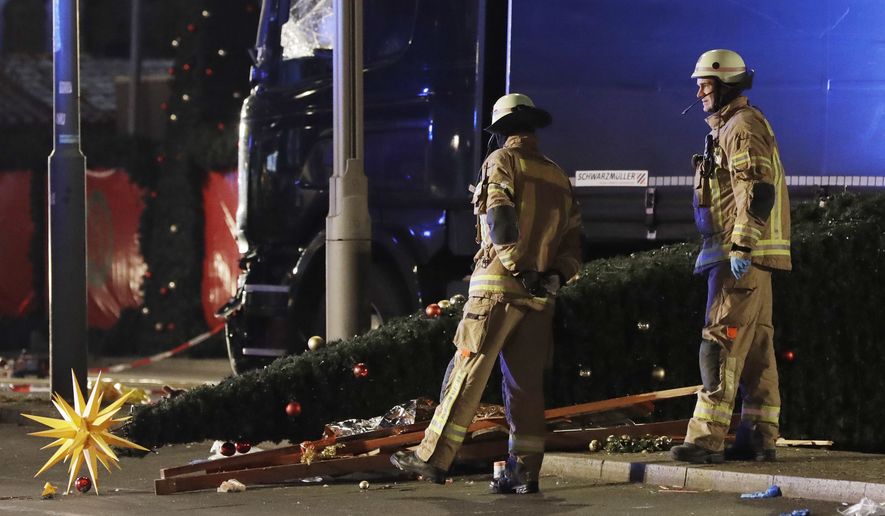 Firefighters look at a toppled Christmas tree after a truck ran into a crowded Christmas market in Berlin, Germany, on Monday. (Associated Press)