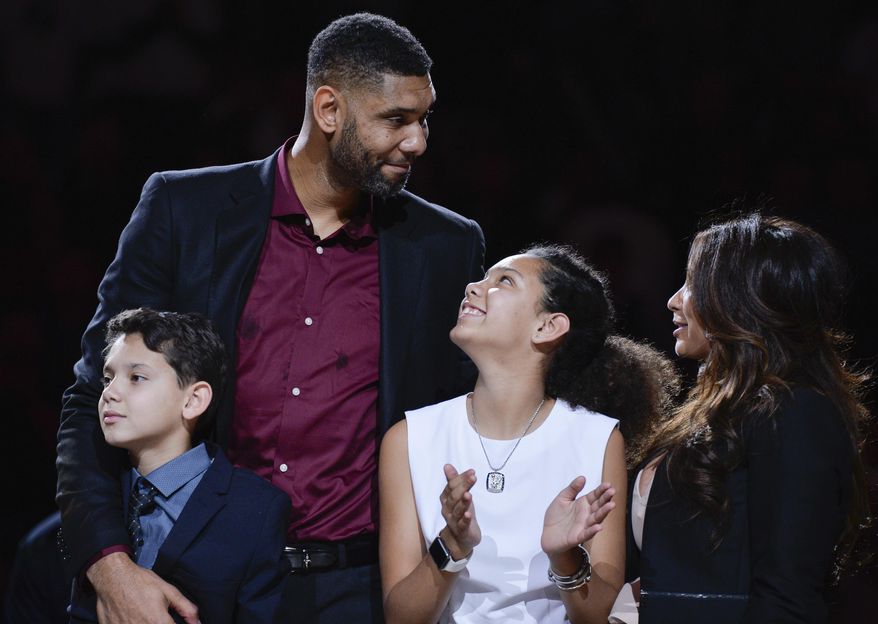 San Antonio Spurs legend Tim Duncan stands with his son Draven, left, daughter Sydney, and girlfriend Vanessa Macias, right, during his jersey retirement ceremony Sunday, Dec. 18, 2016, in San Antonio. (AP Photo/Darren Abate)