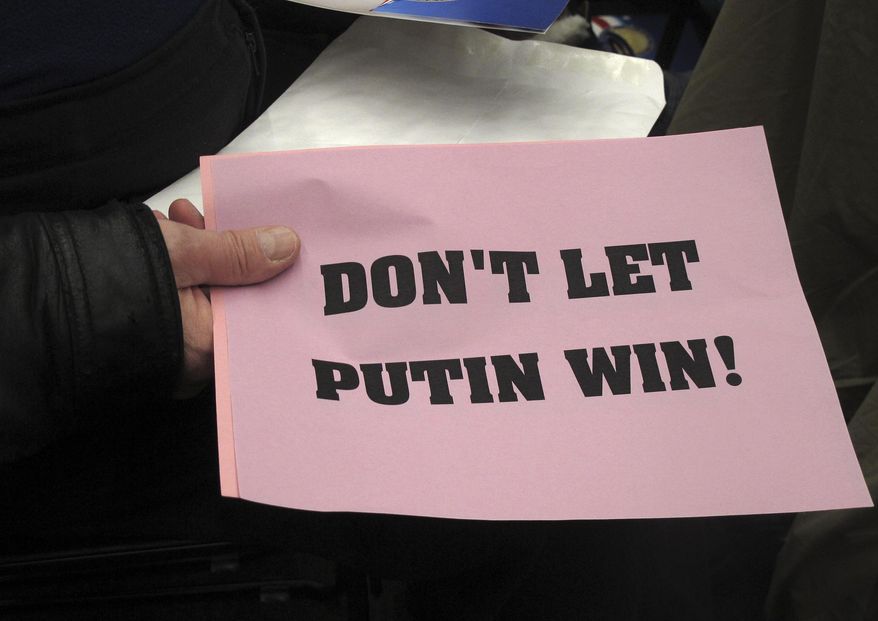 Dennis Harris displays a sign he held up during part of Alaska's Electoral College ceremony on Monday, Dec. 19, 2016, in Juneau, Alaska, in which Alaska's three Republican electors voted for President-elect Donald Trump. Harris said he was exercising his First Amendment rights. (AP Photo/Becky Bohrer)
