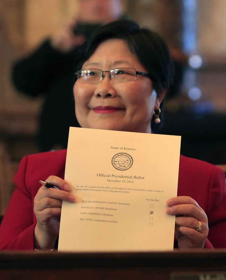Electoral college elector Helen Van Etten holds hers ballot cast for Donald Trump after voting in the Senate chamber of the Kansas Statehouse in Topeka, Kan., Monday, Dec. 19, 2016. (AP Photo/Orlin Wagner)