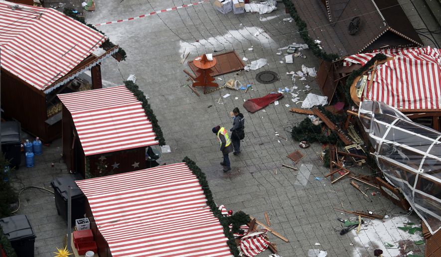 Police officers inspect the crime scene in Berlin, Germany, Tuesday, Dec. 20, 2016, the day after a truck ran into a crowded Christmas market and killed several people. (AP Photo/Markus Schreiber)