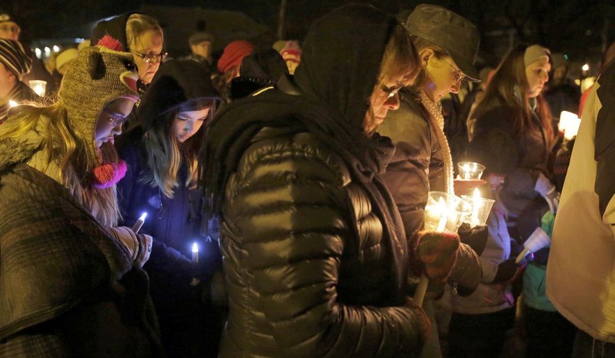 FILE - In this Jan. 29, 2016 file photo, people hold candles in memory of the three deceased Sheboygan Falls children at River Park in Sheboygan Falls, Wis. Natalie Renee Martin, 11, Carter Maki, 7, and Benjamin Martin, 10, died in a house fire Jan. 26. Natalie, who died saving the lives of even younger children, is among 21 people being honored with Carnegie medals for heroism. The Carnegie Hero Fund Commission, based in Pittsburgh, announced the winners Tuesday, Dec. 20. (Gary C. Klein/The Sheboygan Press via AP)