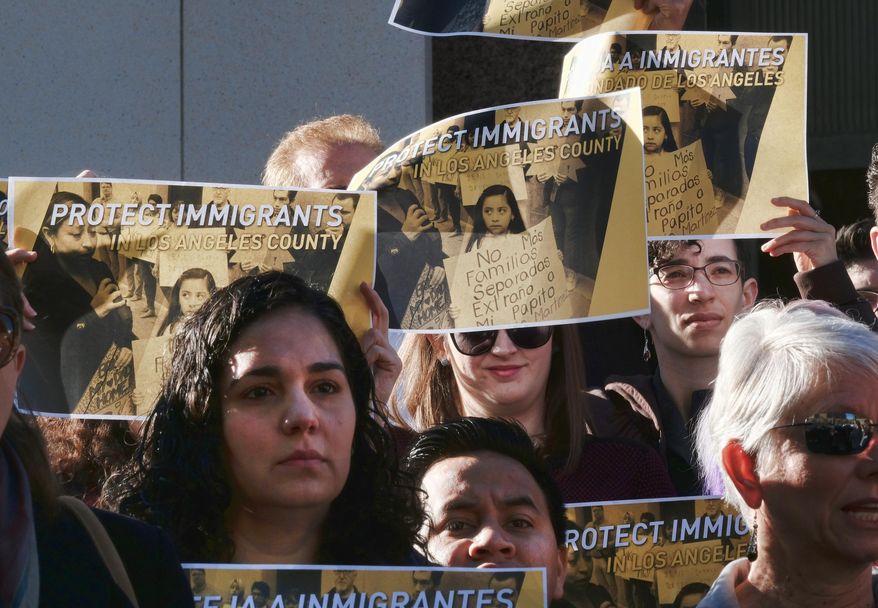 Holding signs that read "Protect Immigrants," pro-immigration demonstrators stand on the steps of the Kenneth Hahn Hall of Administration in downtown Los Angeles on Tuesday, Dec. 20, 2016. The county will consider allocating $3 million to provide lawyers to immigrants following fears of increased deportations under President-elect Donald Trump. The money would form part of a $10 million fund comprised of city, county and private foundation resources. (AP Photo/Richard Vogel)