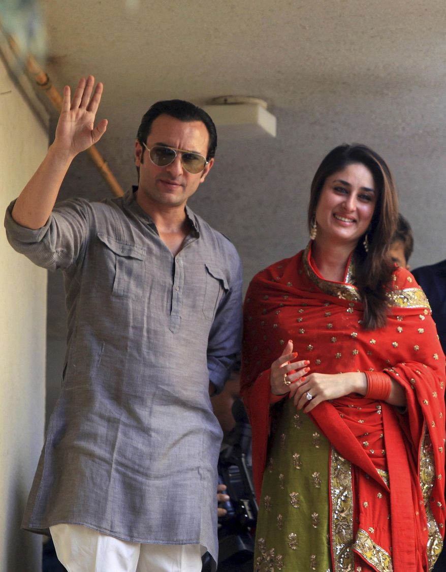 FILE - In this Oct. 16, 2012 file photo, Bollywood stars Saif Ali Khan, left, and Kareena Kapoor step out on a balcony to greet waiting fans after getting married in Mumbai, India. The popular Bollywood couple say they have been blessed with a baby boy. The couple announced the birth of their son in a Mumbai hospital in a tweet on Tuesday, Dec. 20, 2016. (AP Photo/Rajanish Kakade)