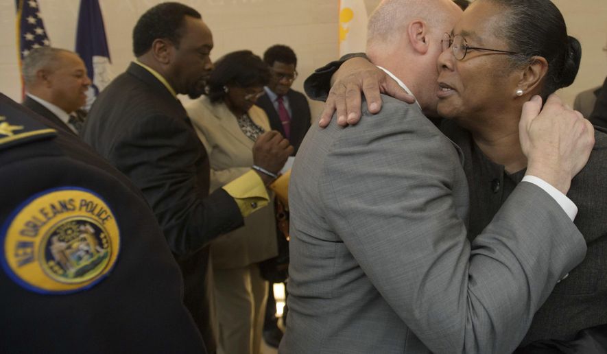 New Orleans Mayor Mitch Landrieu, center right, hugs Jackie Madison Brown, whose brother Ronald Madison was killed by New Orleans Police on the Danziger Bridge after Hurricane Katrina in 2005, after the mayor held a press conference to announce settlements in the civil rights cases, in New Orleans, La. Monday, Dec. 19, 2016. The city said it will pay out $13.3 million to 17 plaintiffs. Landrieu announced the city has reached settlements totaling $13.3 million in lawsuits over the deadly police shootings after Hurricane Katrina and a fatal beating just before the 2005 storm, and he apologized to the victims' families on behalf of the city. (Matthew Hinton/The Advocate via AP)
