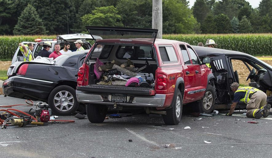 FILE - In this July 18, 2015, file photo, authorities investigate the scene of a fatal crash between a limousine and sports utility vehicle in Cutchogue, N.Y. A special grand jury empaneled after the fatal crash that killed four women in the limousine as it was leaving a New York winery has issued a report calling for better safety regulations for stretch limousines. The report said cars converted into limos often lack safety components, like side-impact airbags, reinforced rollover protection bars and accessible emergency exits, that are required in smaller vehicles. (Randee Daddona/Newsday via AP, File)