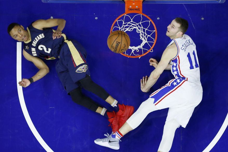 Philadelphia 76ers' Nik Stauskas (11) and New Orleans Pelicans' Tim Frazier (2) watch Stauskas' missed shot during the first half of an NBA basketball game, Tuesday, Dec. 20, 2016, in Philadelphia. (AP Photo/Matt Slocum)