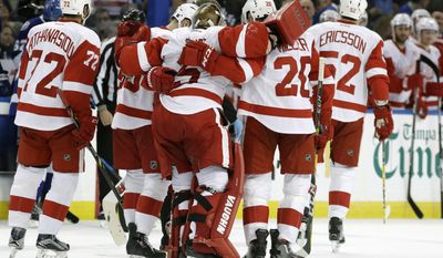 Detroit Red Wings goalie Jimmy Howard (35) is helped off the ice by his teammates after getting injured during the second period of an NHL hockey game against the Tampa Bay Lightning, Tuesday, Dec. 20, 2016, in Tampa, Fla. (AP Photo/Chris O&#39;Meara)