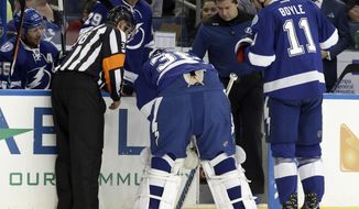Tampa Bay Lightning goalie Ben Bishop (30) is helped off the ice by center Brian Boyle (11) and referee Francois St. Laurent (38) after making a save on a shot by the Detroit Red Wings during the first period of an NHL hockey game Tuesday, Dec. 20, 2016, in Tampa, Fla. (AP Photo/Chris O&#39;Meara)