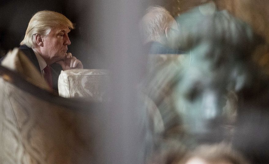 A metal lion is seen in reflection, right as President-elect Donald Trump, left, attends a meeting at Mar-a-Lago, in Palm Beach, Fla., Wednesday, Dec. 21, 2016. (AP Photo/Andrew Harnik)
