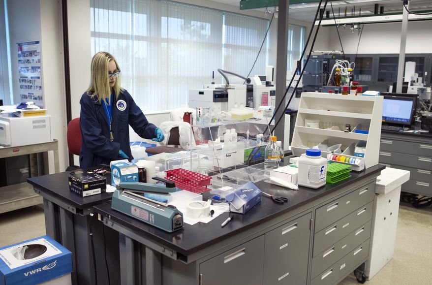 In this Aug. 9, 2016 photo, Forensic Chemist Emily Dye works at the Drug Enforcement Administration (DEA) Special Testing and Research Laboratory in Sterling, Va. The Special Testing Laboratory is one of eight forensic labs run by the DEA. Focused on research, it has a worn functionality that gives it an academic feel. Forty chemists work at the lab. Their job is to identify substances seized by law enforcement in the field before they kill too many people. (AP Photo/Cliff Owen)