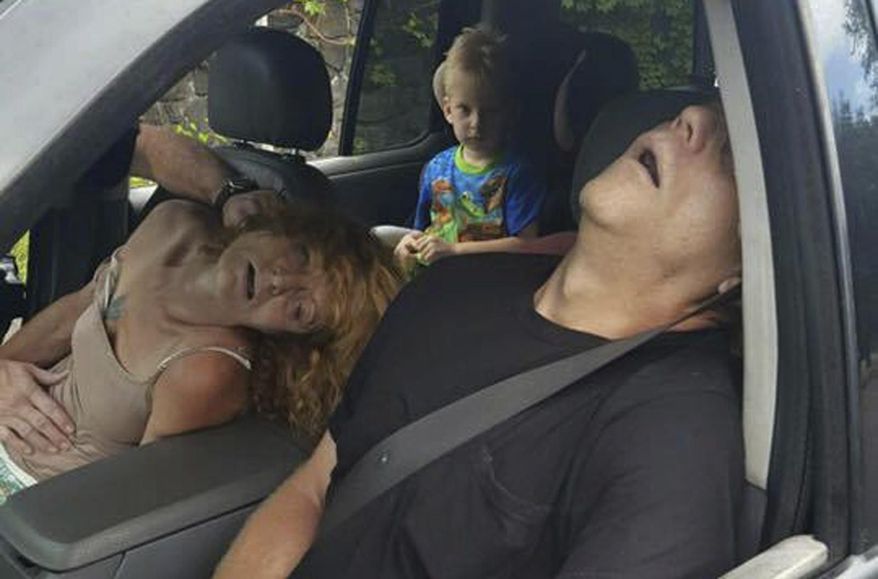 FILE - In this Sept. 7, 2016, file photo, released by the East Liverpool Police Department, a young child sits in a vehicle behind his grandmother, Rhonda Pasek and her boyfriend, James Acord, both of whom are unconscious from a drug overdose, in East Liverpool, Ohio. A judge has given relatives custody of the boy. The East Liverpool Review reports no one contested the granting of custody to the boy’s great aunt and uncle during a hearing Monday, Dec. 19 in Columbiana County. (East Liverpool Police Department via AP, File)