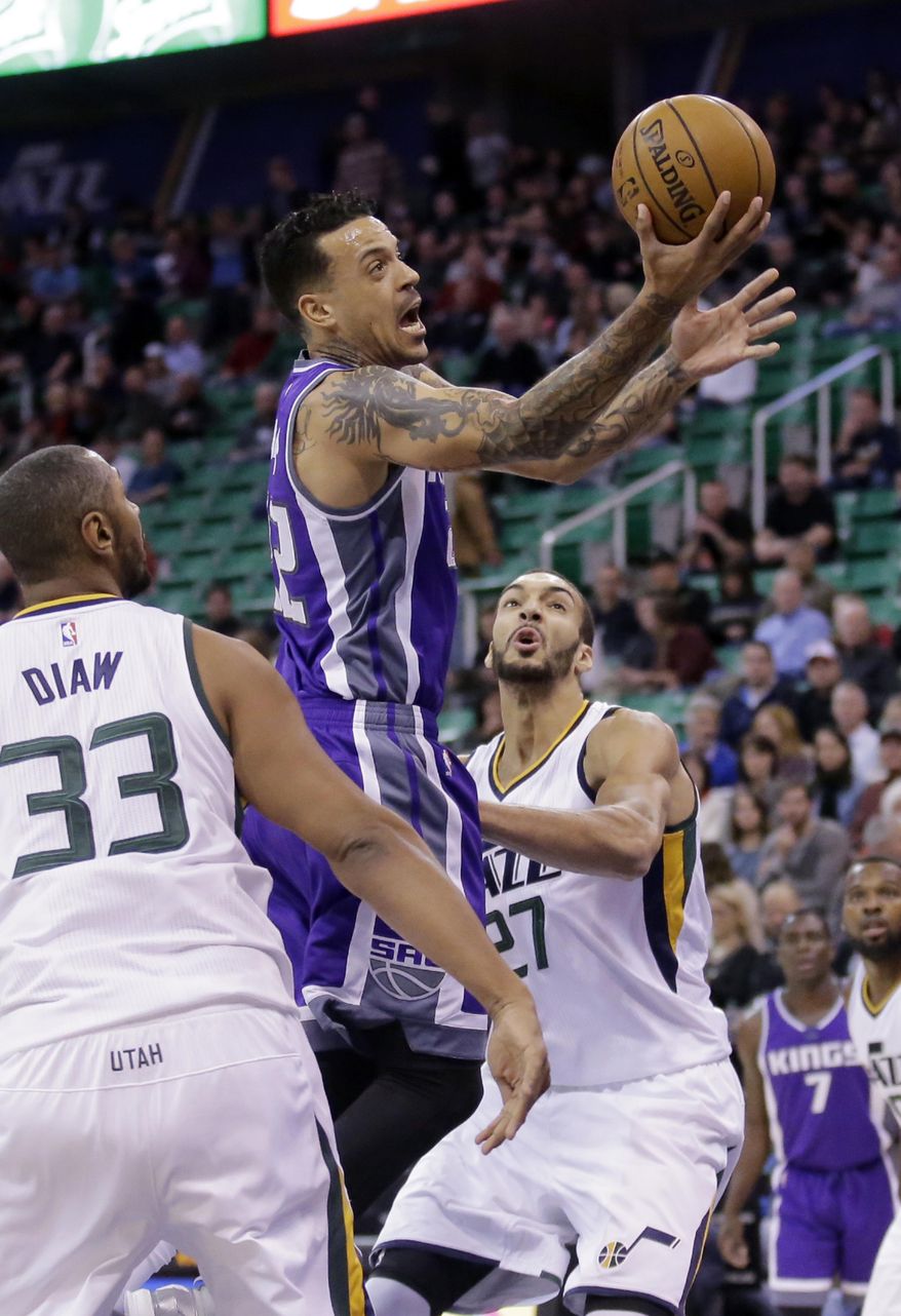 Sacramento Kings forward Matt Barnes, center, goes to the basket as Utah Jazz's Rudy Gobert (27) and Boris Diaw (33) defend in the first half during an NBA basketball game Wednesday, Dec. 21, 2016, in Salt Lake City. (AP Photo/Rick Bowmer)