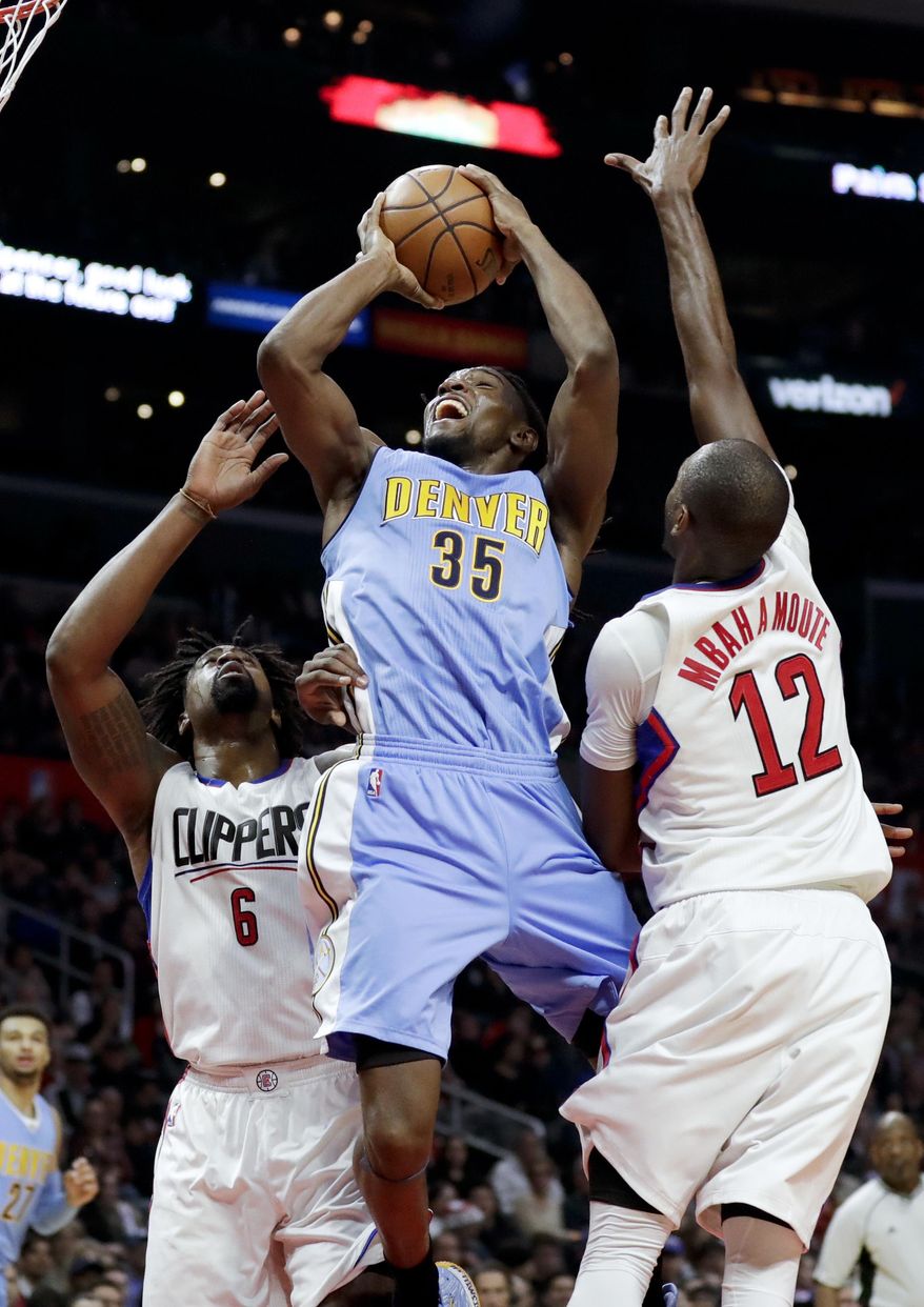 Denver Nuggets forward Kenneth Faried, middle, shoots between Los Angeles Clippers center DeAndre Jordan, left, and forward Luc Mbah a Moute during the second half of an NBA basketball game in Los Angeles, Tuesday, Dec. 20, 2016. (AP Photo/Chris Carlson)